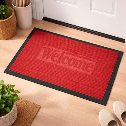 red welcome mat on a wooden floor with plants and shoes in the background